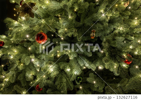 Close-up of a Christmas tree decorated with twinkling lights and colorful ornaments, creating a festive and joyful holiday mood. Close-up of a Christmas tree decorated with twinkling lights and colorful ornaments, creating a festive and joyful holiday mood. 132627116