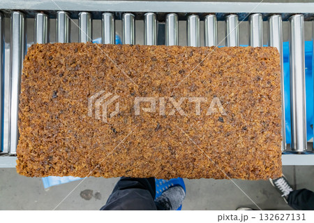 The natural rubber bales products on the industrial automatic conveyor belt machine in a rubber factory. The natural rubber bales products on the industrial automatic conveyor belt machine in a rubber factory. 132627131