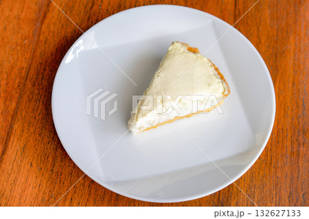 Clear Coconut Cream Pie in the dish on the wood table without anything topping on it. Shooting in the sunlight. 132627133
