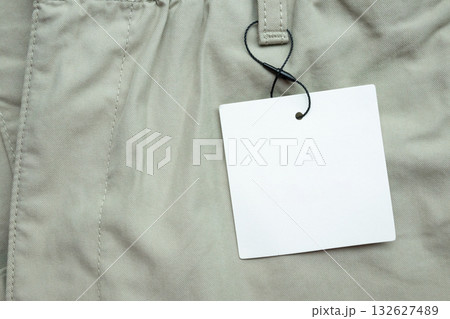 Blank white clothes tag label on gray fabric texture background Blank white clothes tag label on gray fabric texture background 132627489