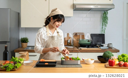 キッチンでお弁当づくりをする女性の横顔 132628021