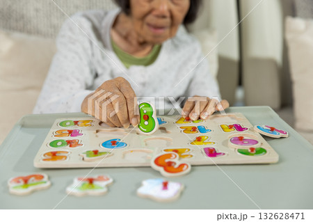 Asian Senior Woman With Dementia is Confuse a Number Puzzle Game. 132628471