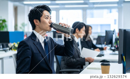 オフィスで水筒からコーヒーを飲む日本人ビジネスマン 132629374