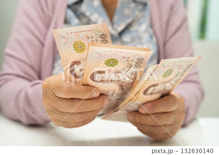 Retired elderly woman counting coins money and worry about monthly expenses and treatment fee payment. 132630140