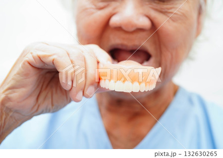 Asian senior woman patient holding teeth denture in her hand for chew food. Asian senior woman patient holding teeth denture in her hand for chew food. 132630265