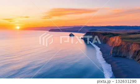 Breathtaking sunset over rugged coastal cliffs and serene ocean waves  Dramatic sky in golden hues reflecting on the calm tranquil waters of the picturesque seascape  Idyllic 132631290