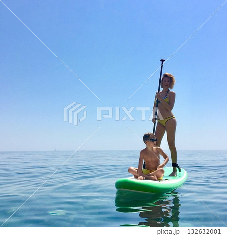 Sup board. water sport. a young man stands on a board in the sea Sup board. water sport. a young man stands on a board in the sea 132632001