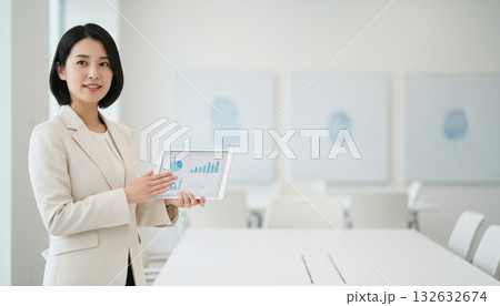 ビジネスシーン:タブレットを持って説明をする若くて美しい女性会社員 ビジネスシーン:タブレットを持って説明をする若くて美しい女性会社員 132632674