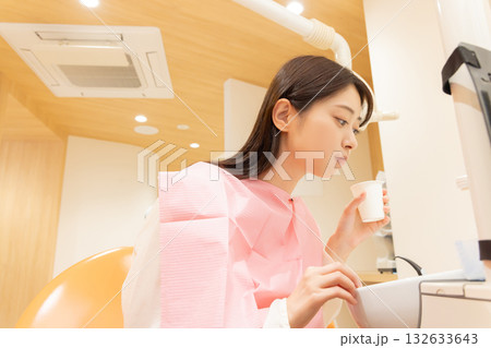 歯の背術後、口を濯ぐ女性 132633643