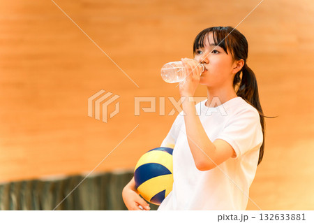 運動中に水分補給する体育館でバレーボールをする体操着姿の女子中学生・女子高生 132633881