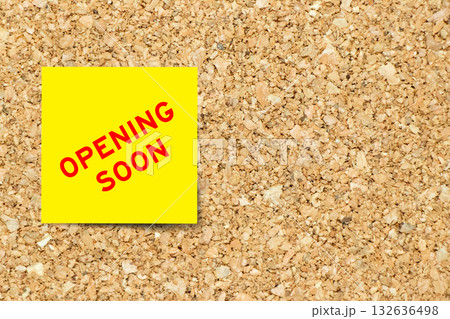 Yellow note paper with word opening soon on cork board background with copy space 132636498