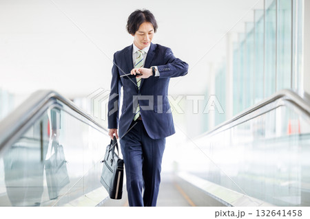 エスカレーターに乗るビジネスマン 132641458