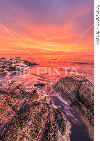 朝焼けに染まる静かな岩礁の海 132641631