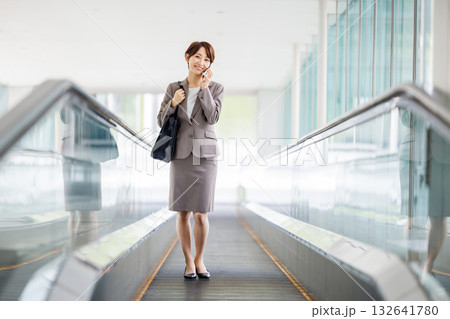 エスカレーターに乗るビジネスウーマン 132641780