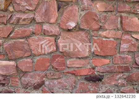 The wall of large raw granite stones of red color, background granite non-uniform 132642230