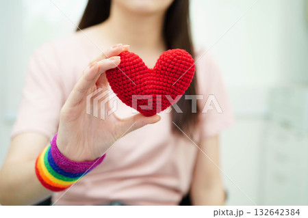 Asian woman holding LGBT heart with rainbow flag. 132642384