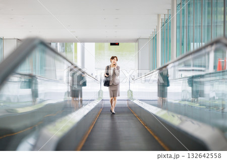 エスカレーターに乗るビジネスウーマン 132642558