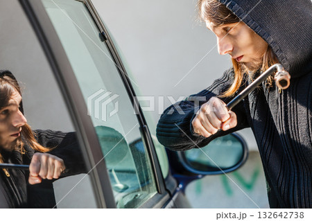 Thief burglar breaking smashing the car window Thief burglar breaking smashing the car window 132642738