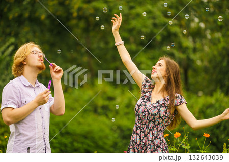 Couple blowing bubbles outdoor Couple blowing bubbles outdoor 132643039