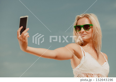 Girl with phone taking selfie. 132643196