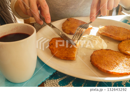 Delicious potato pancakes on plate with sour cream Delicious potato pancakes on plate with sour cream 132643292