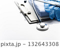 Healthcare medical background with copy-space of stethoscope, clipboard, gloves and folded overalls on white table 132643308