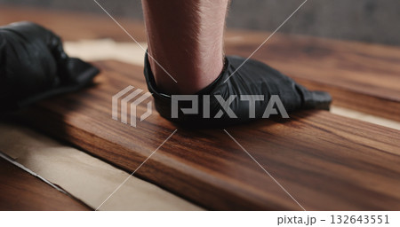 woodworker applying oil finish to black walnut board woodworker applying oil finish to black walnut board 132643551