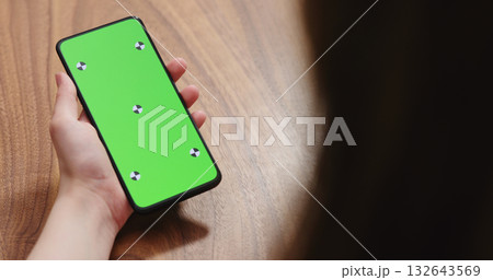young woman holding smartphone over walnut table young woman holding smartphone over walnut table 132643569