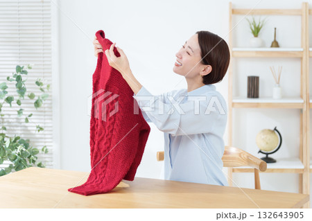 衣替えでセーターを出す女性 衣替えでセーターを出す女性 132643905