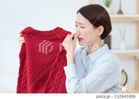 衣替えで出したセーターの臭いを嗅ぐ女性 132643906