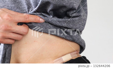 お腹に絆創膏を貼った人物のクローズアップ 132644206