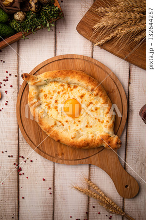 Khachapuri with egg on wooden board Khachapuri with egg on wooden board 132644287