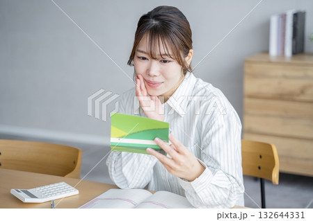 通帳を眺める女性 132644331