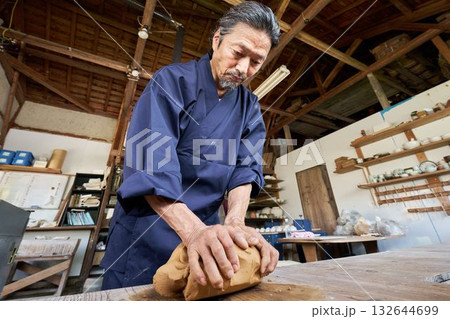 陶芸工房で粘土をこねるシニア男性 132644699