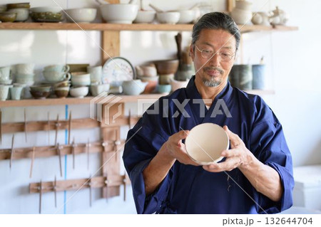 作品をチェックするベテラン陶芸家 132644704