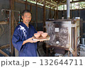 窯の前に立って笑顔を見せるベテラン陶芸家 132644711