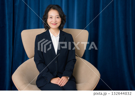 大きな椅子に座るミドルビジネスウーマン 132644832