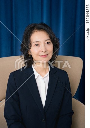 大きな椅子に座るミドルビジネスウーマン 132644838