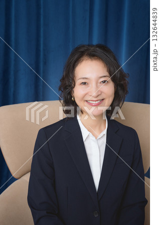 大きな椅子に座るミドルビジネスウーマン 132644839