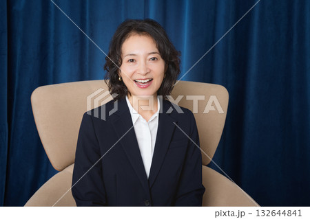 大きな椅子に座るミドルビジネスウーマン 132644841