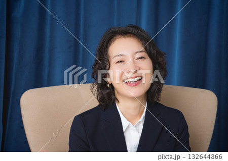 大きな椅子に座るミドルビジネスウーマン 132644866