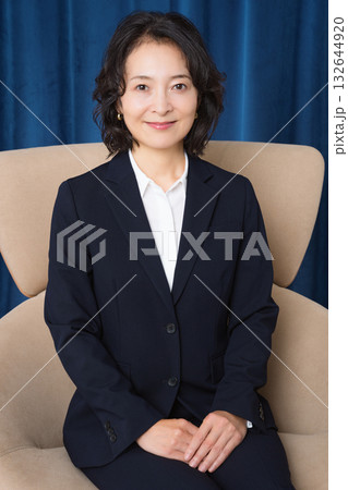 大きな椅子に座るミドルビジネスウーマン 大きな椅子に座るミドルビジネスウーマン 132644920