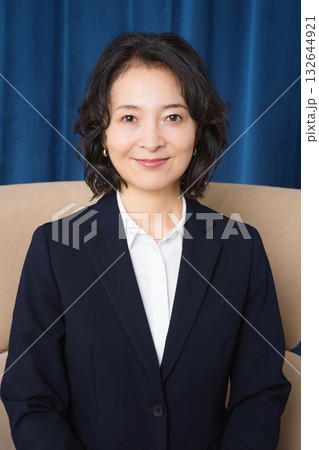 大きな椅子に座るミドルビジネスウーマン 132644921