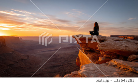 A person meditating on top of a sandstone formation at sunset. beautiful desert background. gorgeous scene straight out Arabian fairy tale, where sand, heat, silence reign. A person meditating on top of a sandstone formation at sunset. beautiful desert background. gorgeous scene straight out Arabian fairy tale, where sand, heat, silence reign. 132645283