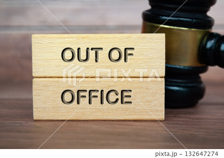 Out of office text engraved on wooden blocks with gavel background. Getaway or on a vacation concept. 132647274