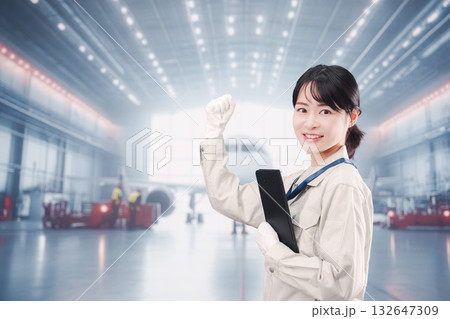 飛行機の格納庫で働く技術者の若い女性 飛行機の格納庫で働く技術者の若い女性 132647309