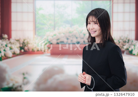 お葬式で喪服を着て数珠を持つ若い女性 お葬式で喪服を着て数珠を持つ若い女性 132647910