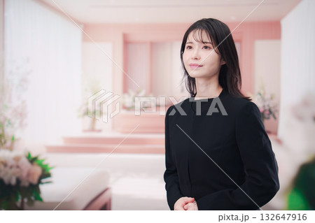 お葬式で喪服を着て数珠を持つ若い女性 132647916