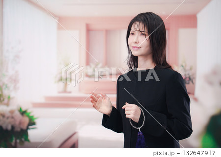 お葬式で喪服を着て数珠を持つ若い女性 132647917