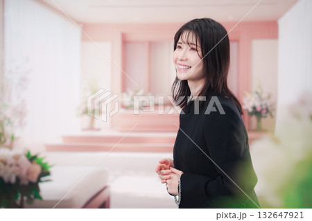 お葬式で喪服を着て数珠を持つ若い女性 132647921